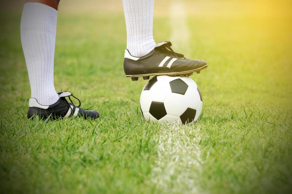 soccer-player-standing-with-ball-on-the-field-free-photo